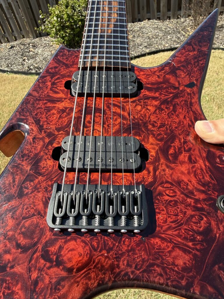 Red-orange burl top detail on a T.W. Smith Vulture 7 guitar
